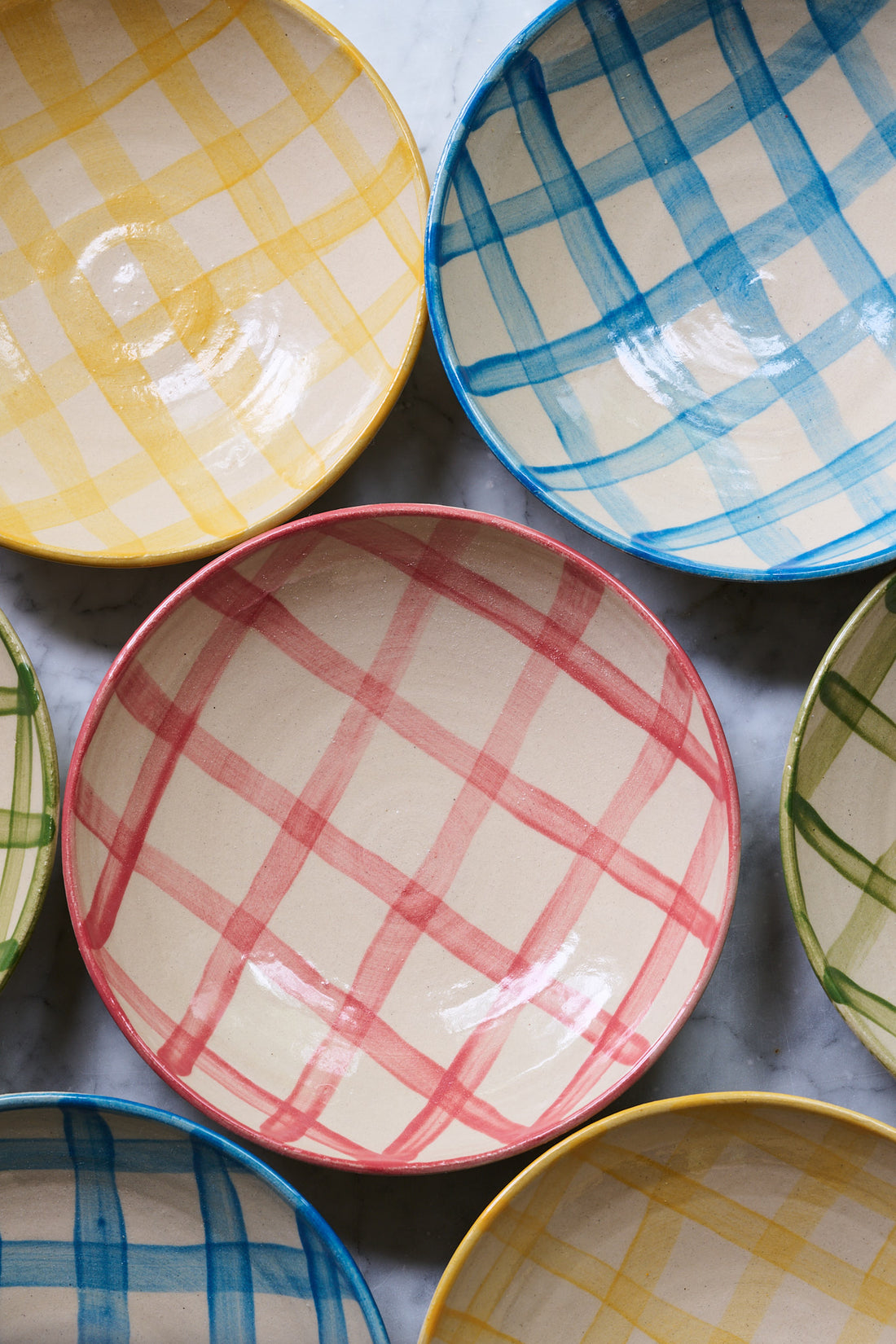 Set of colorful checkered ceramic bowls on a gray surface